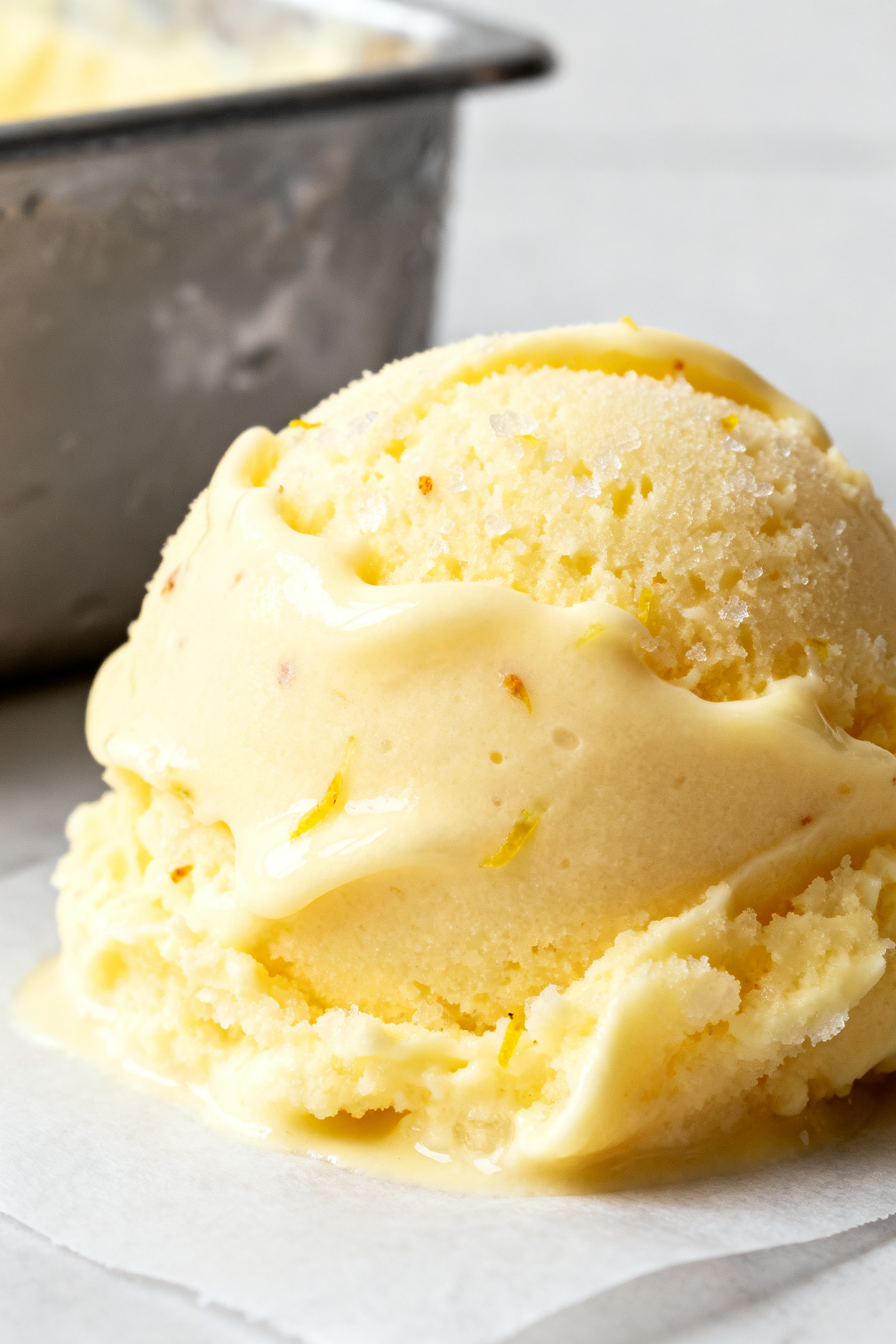 Close-up detail: Silky no-sugar lemon sorbet scooped like soft-serve straight from the churn, tight 