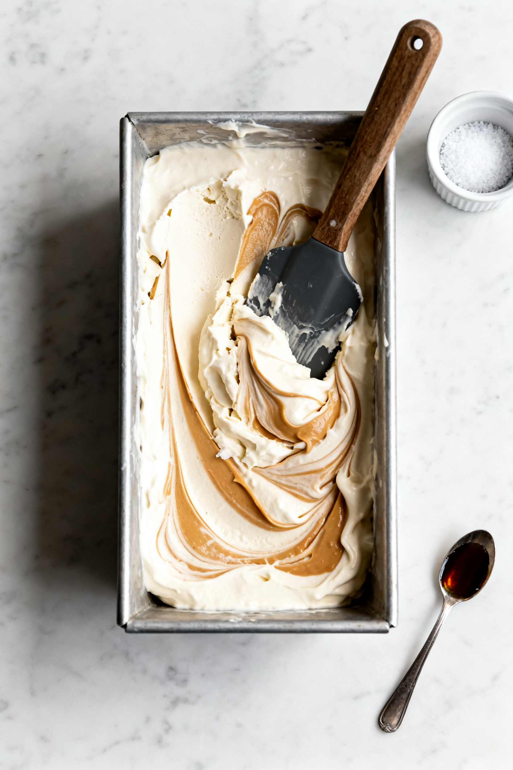 Cooking process: Overhead shot of the chilled yogurt base mid-no-churn method in a shallow metal loa