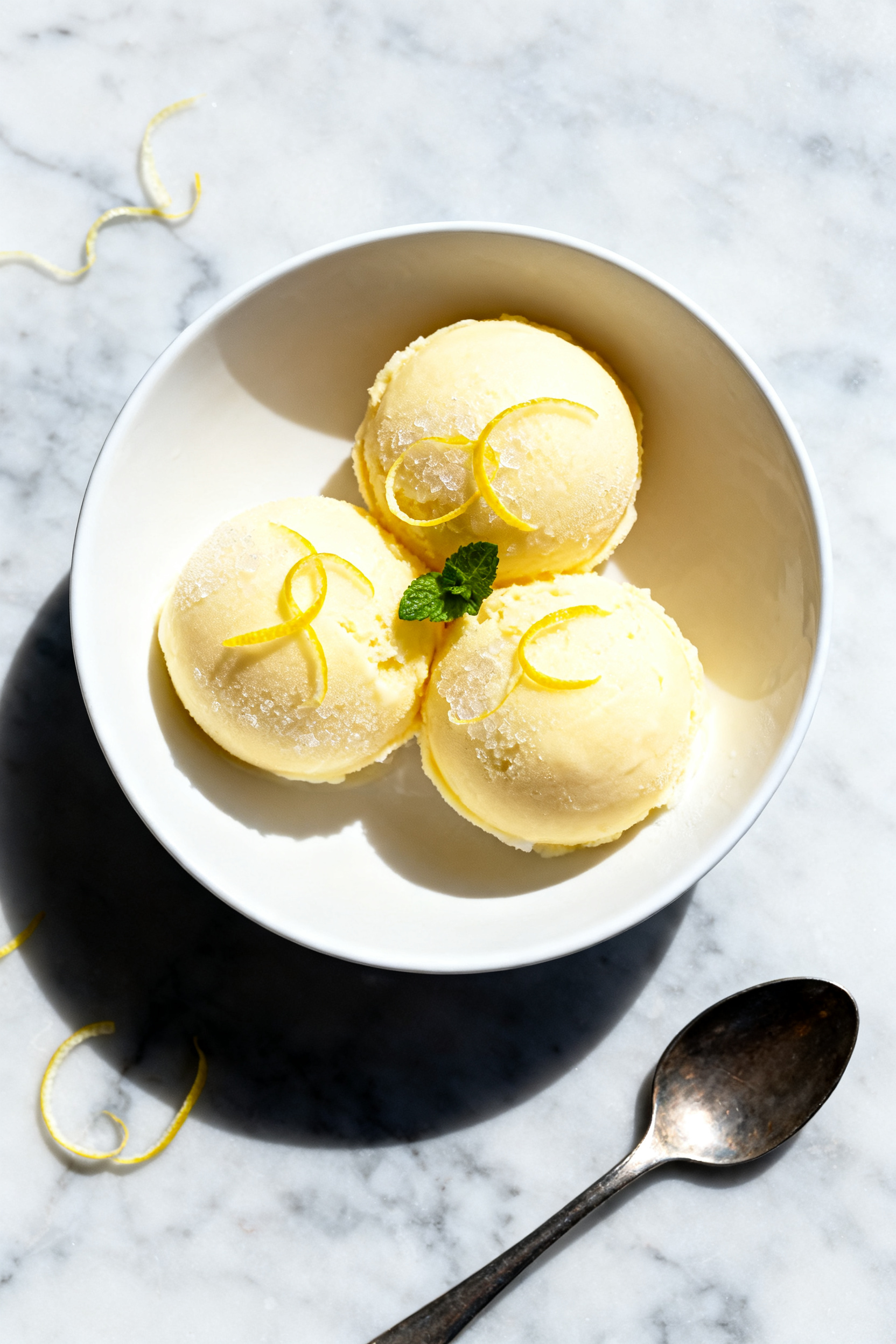 Final dish, tasty top view: Overhead shot of perfectly set no sugar lemon sorbet, three round quenel