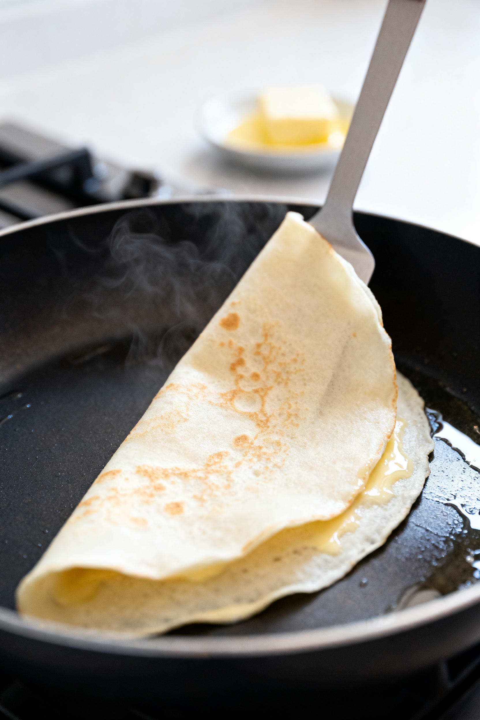 Cooking process close-up: A thin protein crepe just after the flip in an 8–10 inch nonstick skille